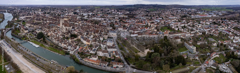 Aerial around the old town of the city Dole in France on a cloudy afternoon in late winter