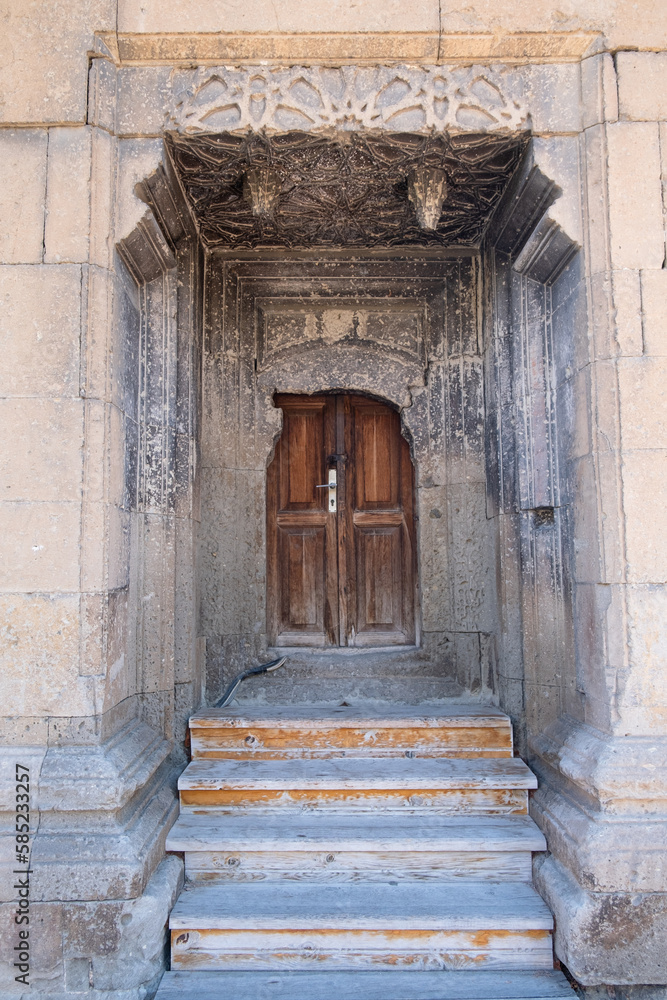 A building with decorative historical old stones and old carved wooden door. Museum of Amasya, Turkey