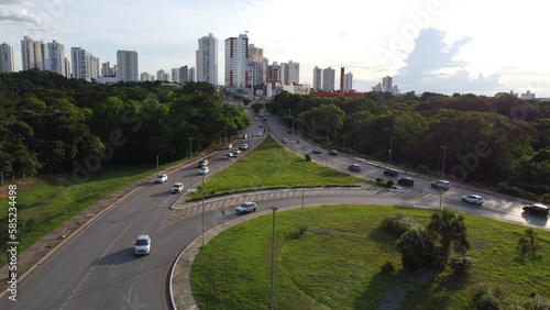 Image of an avenue in Cuiaba, Mato Grosso - Brazil showing a large green vegetation and buildings in the background. photo