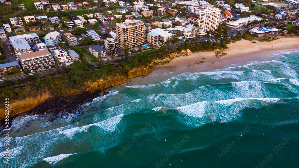 Aerial, drone view of the spectacular Sunshine Coast city near Brisbane. Beautiful buildings on the cliffs and golden sand beaches at sunrise. Landscape of Queensland, Australia
