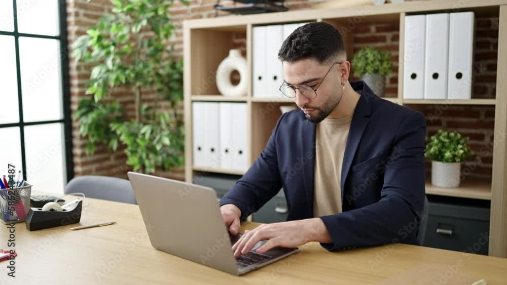 Young arab man business worker using laptop with winner expression at office Young arab man business worker using laptop with winner expression at office