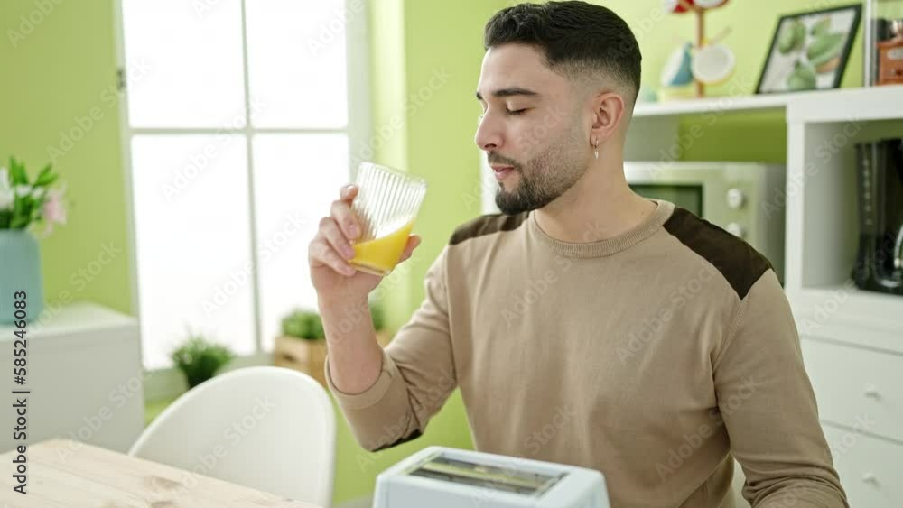 Young arab man having breakfast sitting on table at home Young arab man having breakfast sitting on table at home