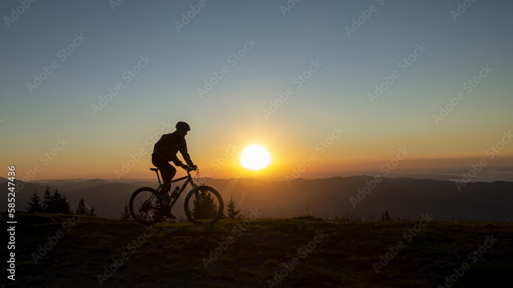 Fototapeta premium silhouette of a mountain biker towards a wonderful sunset