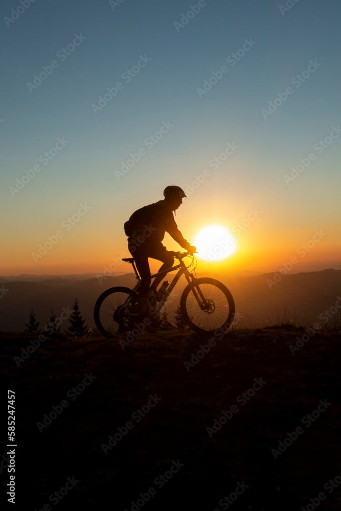 Obraz premium silhouette of a mountain biker towards a wonderful sunset