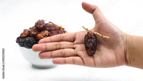 hand pick a dried date fruit from a bowl