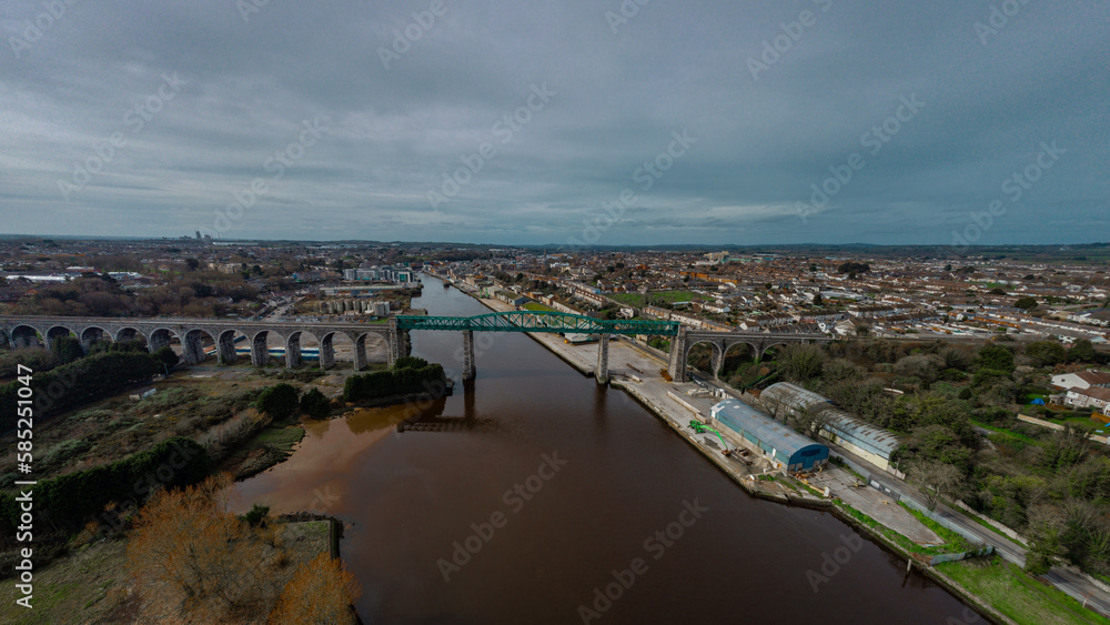Aerial drone view of Boyne viaduct in drogheda spanning over river Boyne in early evening hours. Beautiful pucture of a green metal viaduct and stone arches.
