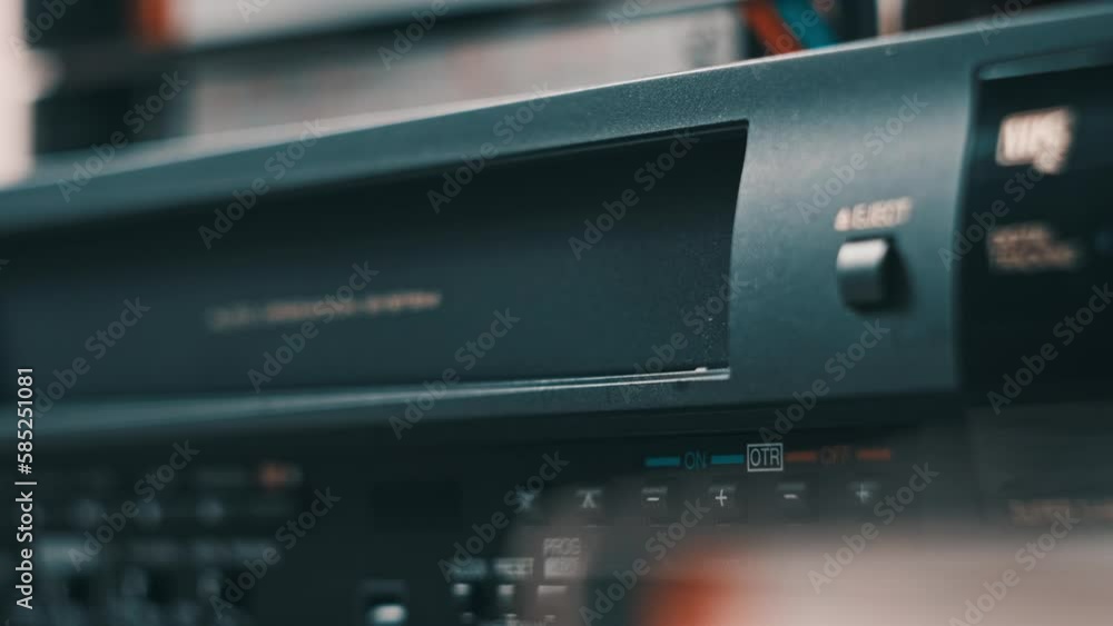 Eject VHS tape cassette from VCR player. Male hand pushes a button and