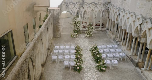 Decorated white chairs for guests near colonnaded gallery