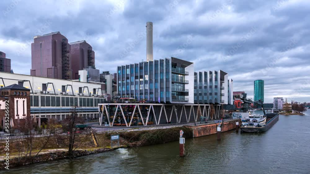 Frankfurt am Main, Germany - January 30, 2023: Time lapse - Industrial plant in front of West Harbor living area in Frankfurt am Main, Germany, by overcast weather. Frankfurt am Main, Germany - January 30, 2023: Time lapse - Industrial plant in front of West Harbor living area in Frankfurt am Main, Germany, by overcast weather.