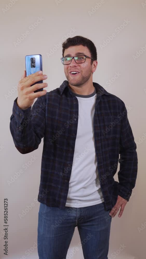 White man talking cheerfully on video call with cell phone, expressive and waving. White man talking cheerfully on video call with cell phone, expressive and waving.