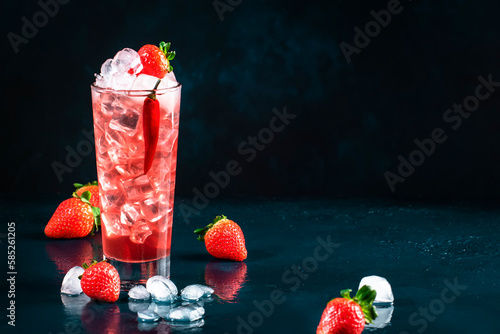 Oldboy alcoholic cocktail drink with vodka, grapefruit juice, strawberries, sugar, cinnamon and hot chili pepper. Highball glass on dark blue background photo