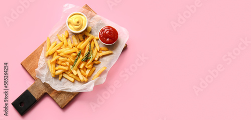 Tasty french fries and sauces on pink background with space for text