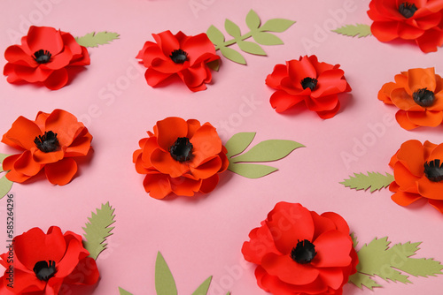 Paper poppy flowers with leaves on pink background