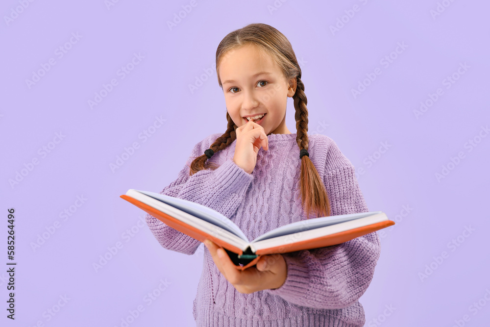 Little girl with book biting nails on lilac background Little girl with book biting nails on lilac background