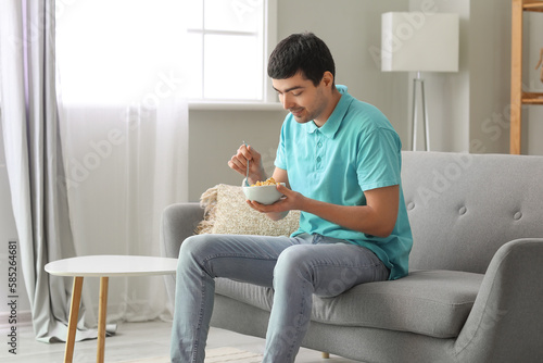 Young man eating cornflakes...
