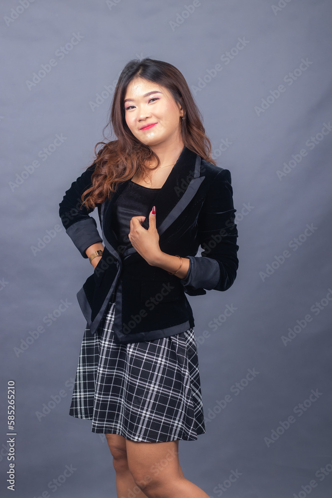 beautiful chinese asian women dressed in formal office wear jackets and skirts. the girl's expression smiled thinly in a formal pose, all her hands were holding a jacket and her body was tilted beautiful chinese asian women dressed in formal office wear jackets and skirts. the girl's expression smiled thinly in a formal pose, all her hands were holding a jacket and her body was tilted
