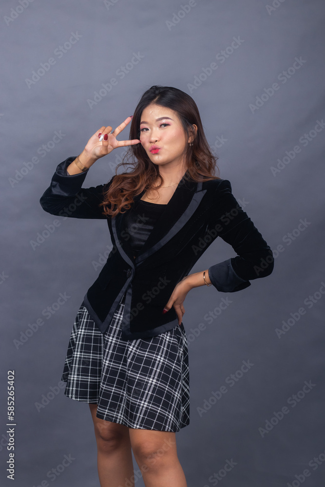beautiful chinese asian women dressed in formal office wear jackets and skirts. the girl's expression is sullen in a formal pose, her hands are showing a peace sign beautiful chinese asian women dressed in formal office wear jackets and skirts. the girl's expression is sullen in a formal pose, her hands are showing a peace sign