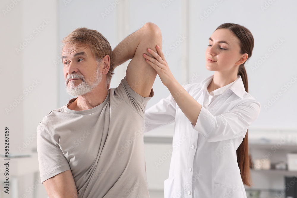 Obraz premium Professional orthopedist examining patient's shoulder in clinic