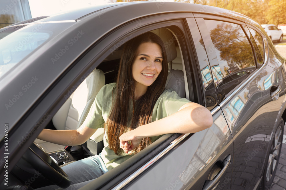 Beautiful young woman driving car on sunny day
