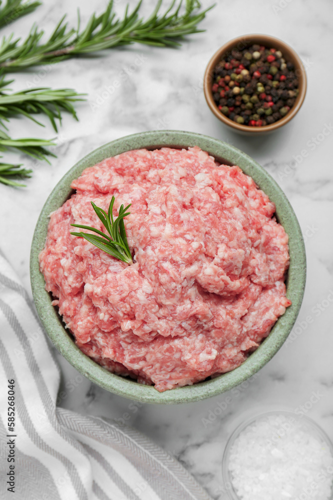 Bowl of raw fresh minced meat with rosemary and spices on white Bowl of raw fresh minced meat with rosemary and spices on white