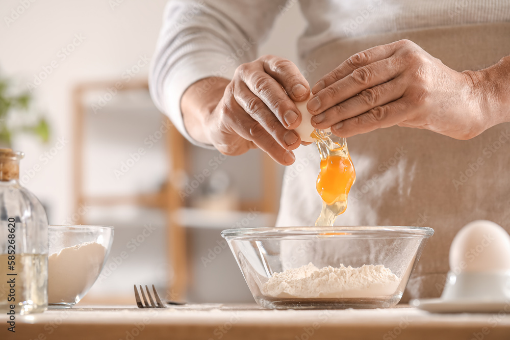 Male chef making dough for pasta at table in kitchen, closeup Male chef making dough for pasta at table in kitchen, closeup