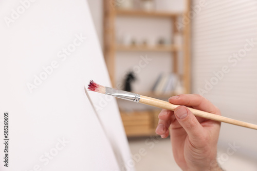 Man painting on canvas in studio  closeup