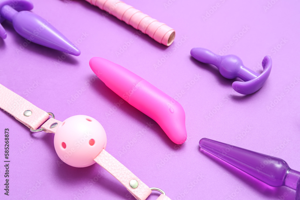 Different sex toys on purple background, closeup Different sex toys on purple background, closeup
