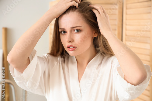 Young woman with hair loss problem at home