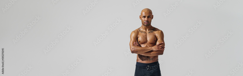 Fototapeta premium Attractive sporty man with muscled naked body on white studio background looking at camera