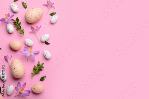 Composition with Easter eggs, beautiful crocus flowers and plant leaves on pink background