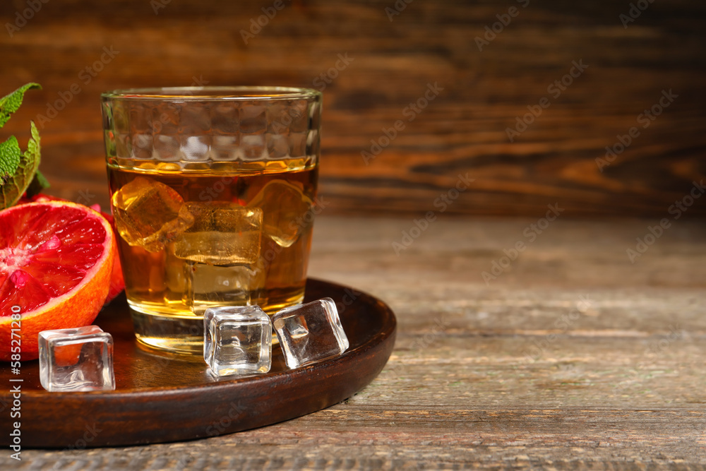 Glass of rum with ice and Sicilian orange on table Glass of rum with ice and Sicilian orange on table
