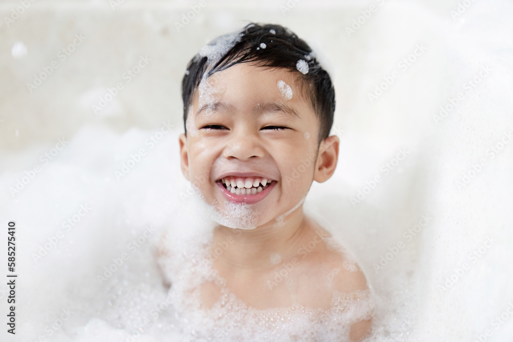 boy taking a bath in the tub take bath he plays with bubbles Stock