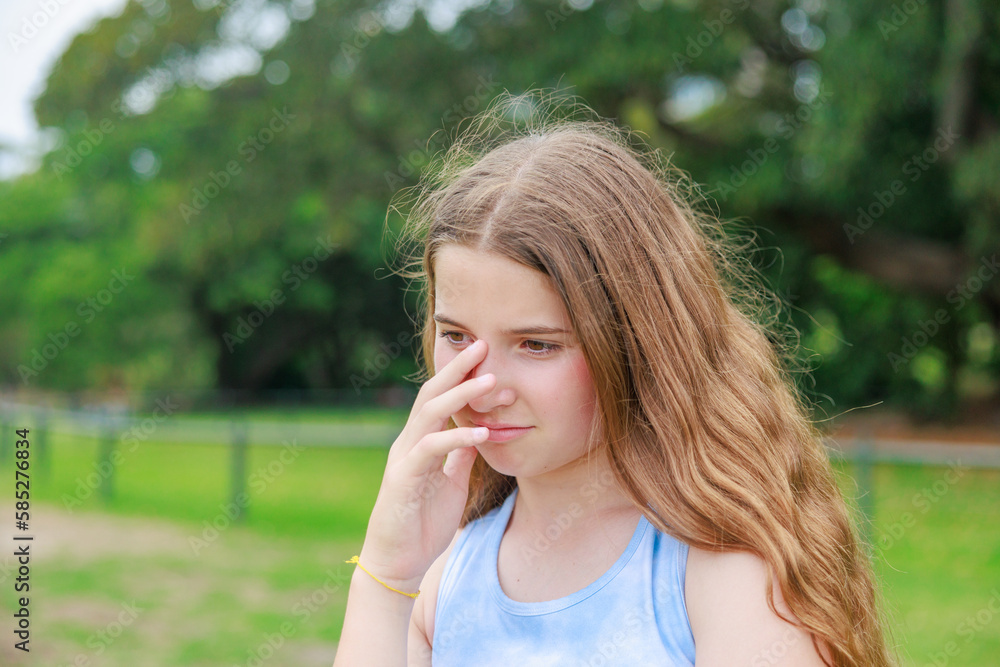 新緑の公園で悲しむ表情のオーストラリアの少女