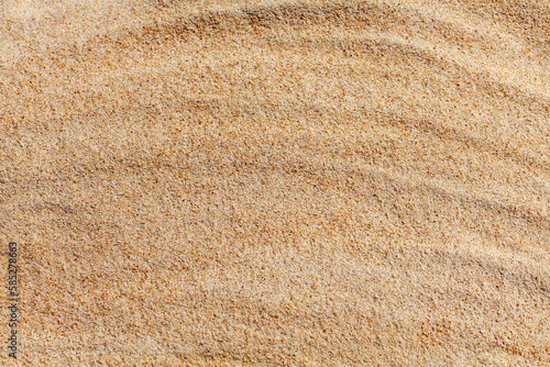Wavy yellow sand texture closeup background, sandy waves pattern, natural beige sand grains backdrop, rippled dry sand surface top view, light orange desert dune, summer tropical sea beach, copy space