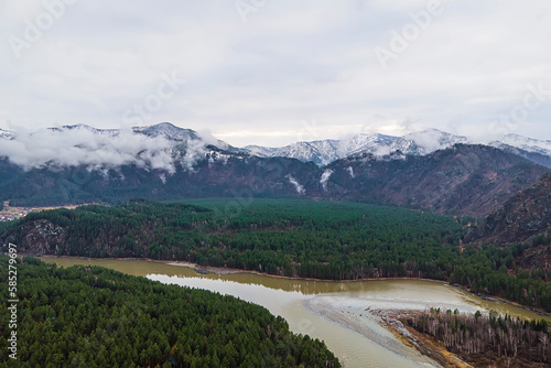 Fototapeta Naklejka Na Ścianę i Meble -  Early morning on the Katun river, Altai. The river at dawn against the backdrop of the mountains, stones on the banks of the river, high mountains, soft sunlight, summer in the mountains, sunny day.