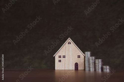 House with coins stack in graph shape for real estate or money savings planning and bank home loan or financial investment insurance.