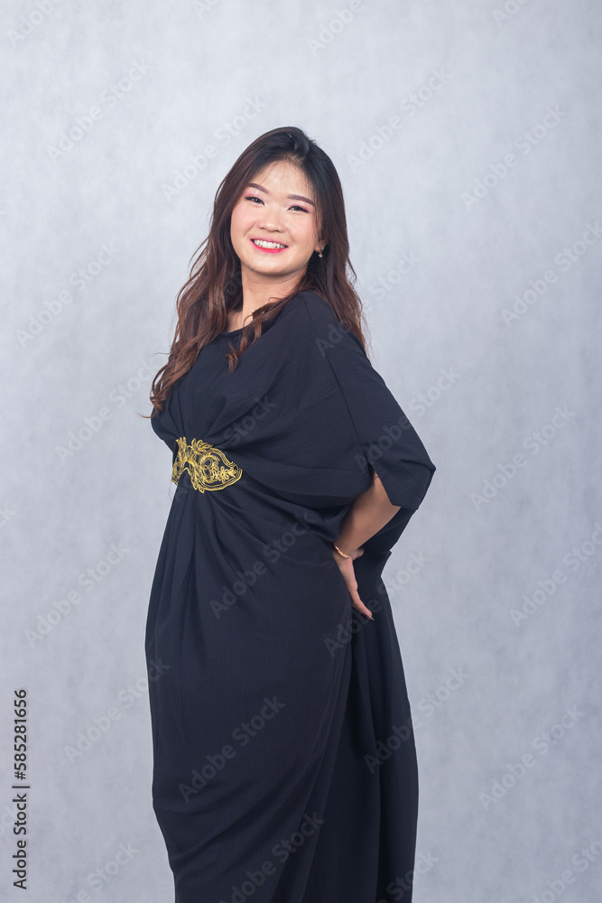 Fototapeta premium Asian chinese muslim headscarf hijab woman greeting ramadan fasting eid al fitr and eid al adha on white background. girl smiling expression her hand holding the back dress tail