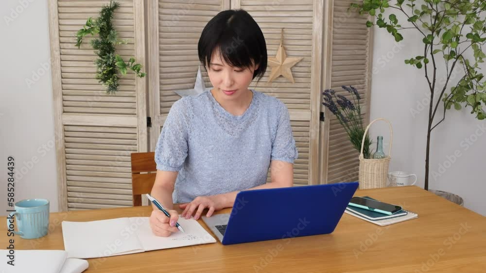 自宅でノートパソコンを使って勉強する女性 自宅でノートパソコンを使って勉強する女性