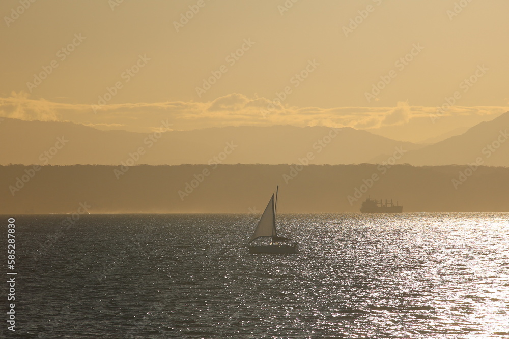 Sailboat sailing into the golden sunset