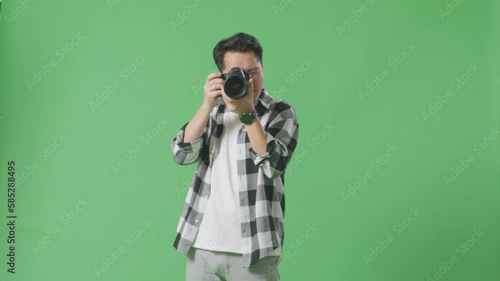 Asian Photographer Using A Camera Taking Pictures And Smiling Touching His Chest While Standing On Green Screen Background In The Studio
Asian Photographer Using A Camera Taking Pictures And Smiling Touching His Chest While Standing On Green Screen Background In The Studio