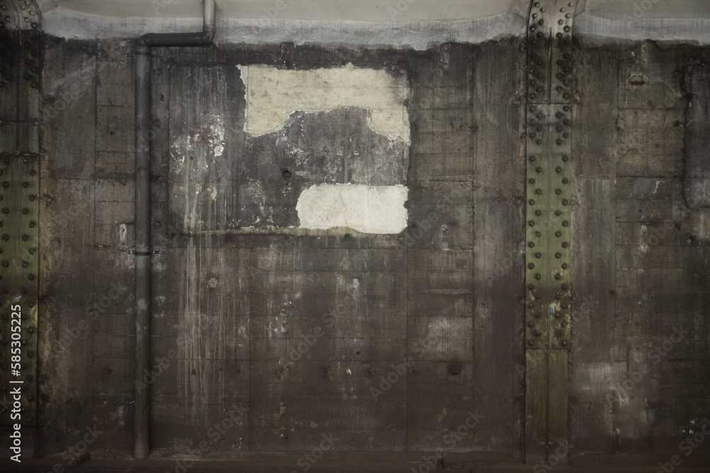 Obraz premium 背景 : パイプと鉄柱とボルトとポスター跡のある、コンクリート打ちっ放しの、地下鉄の壁