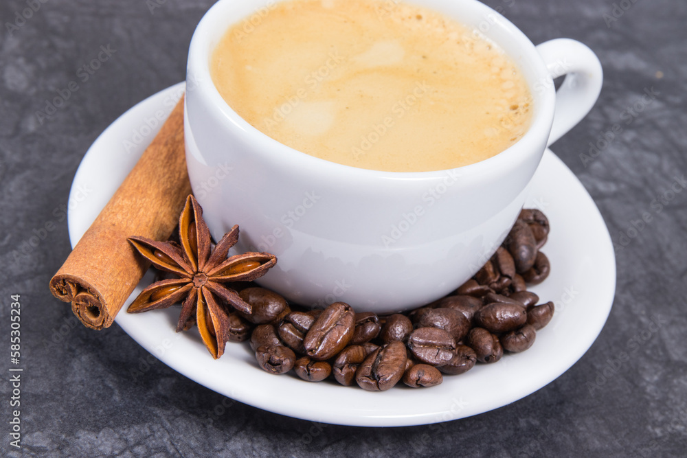 Coffee in white cup and roasted dark coffee beans with seasonings Coffee in white cup and roasted dark coffee beans with seasonings