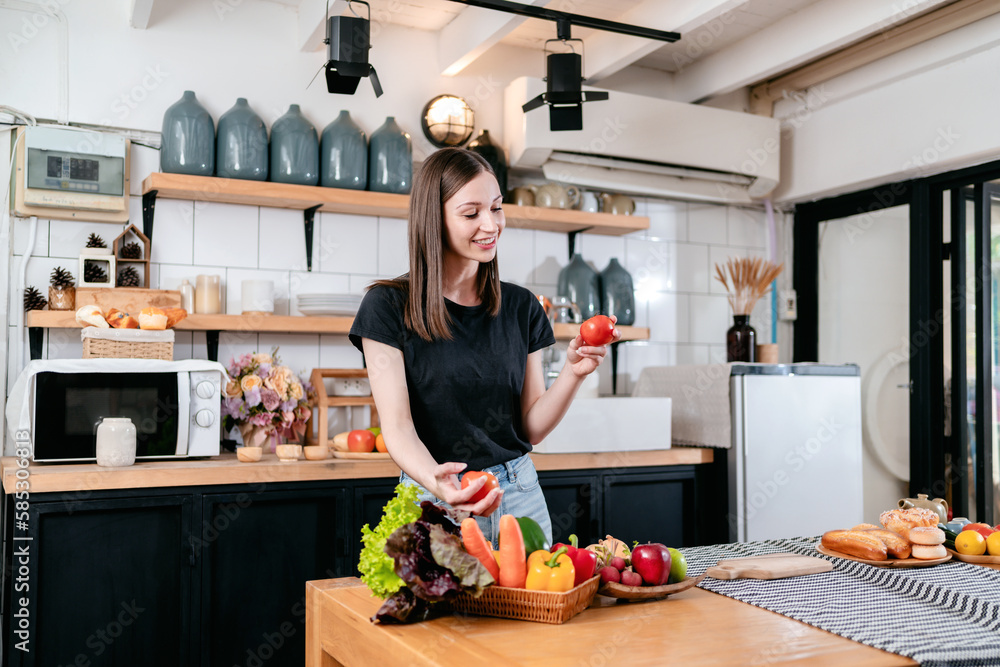 Woman holding tomato in her hands with enjoying while preparing