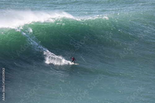 Surfers ride on large sea waves