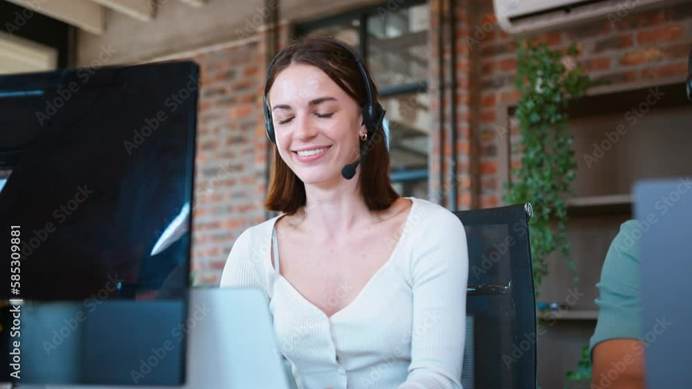 Businesswoman in  business team wearing headsets in customer support centre - shot in slow motion
