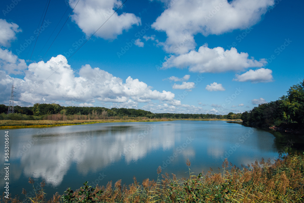 vue d'un lac en automne. Paysage d'un lac en France. étang de Longpendu. Ciel bleu et nuages se reflétant sur un lac. Ligne haute tension sur un lac