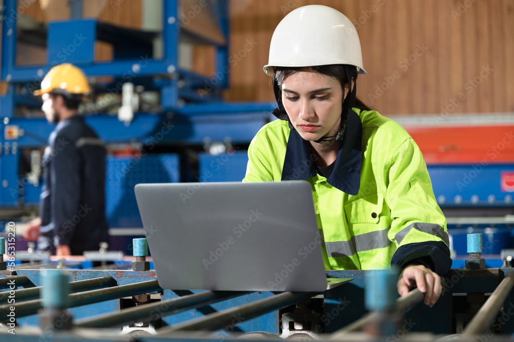 Portrait engineer woman use computer notebook working with machine background at metal sheet factory	
