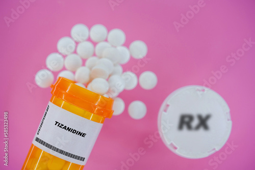 Tizanidine Rx medicine pills in plactic vial with tablets. Pills spilling   from yellow container on pink background. photo