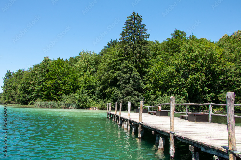Wooden pier edging into the magnificent turquoise waters of Lake Kozjak in Plitvice Lakes National Park in Croatia