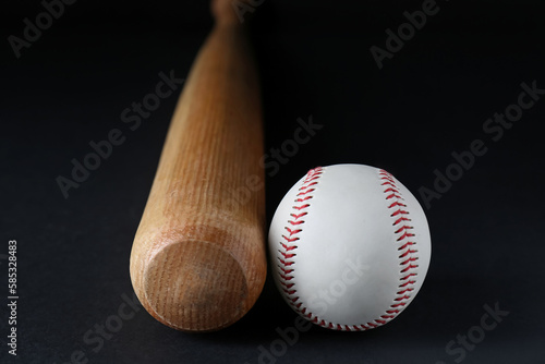 Photography Wooden baseball bat and ball on black background, closeup